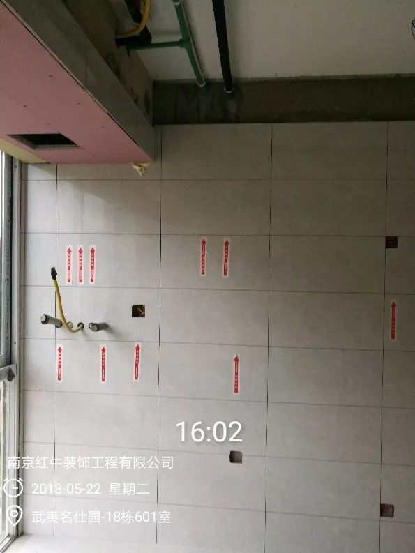 南京武夷名仕園124平米簡(jiǎn)美風(fēng)格裝修  享受家?guī)?lái)的溫度30五月份_墻磚鋪貼完成后，紅牛裝飾的工人會(huì)用專用護(hù)角條對(duì)瓷磚角保護(hù)，用標(biāo)貼標(biāo)出水管、線管走向示意。